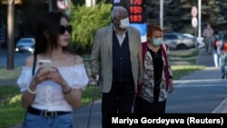 Люди идут по улице во время вспышки коронавирусной болезни (COVID-19) в Алматы, Казахстан, 29 июня 2020 г.  