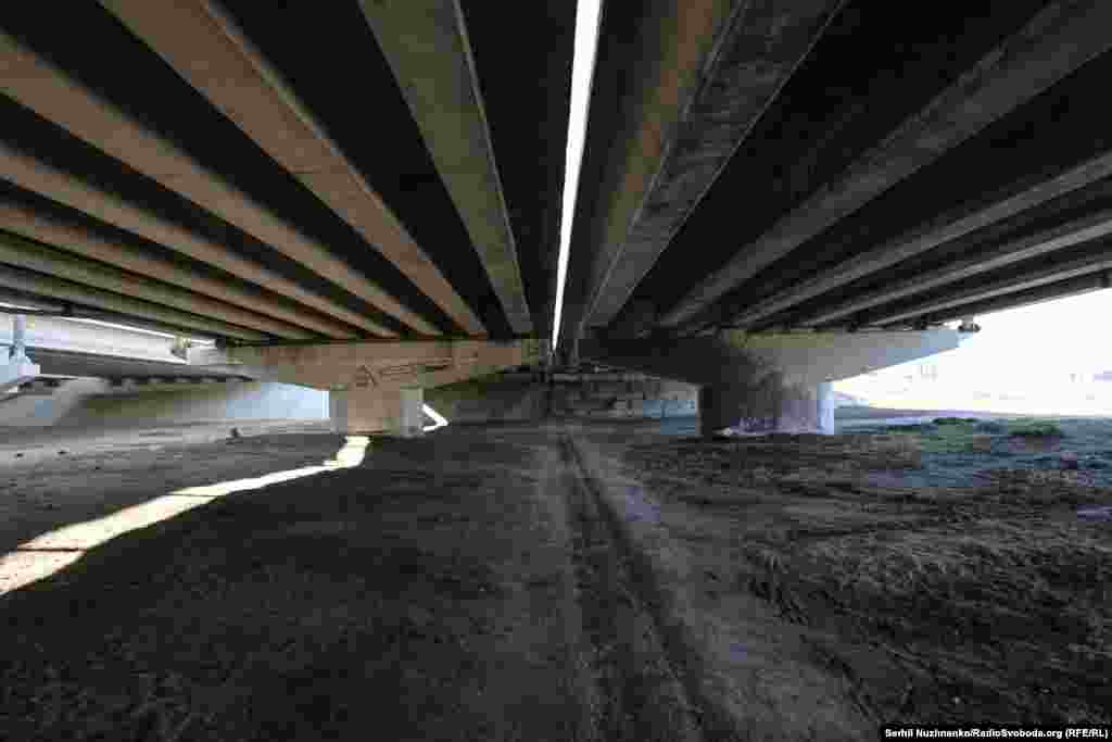 Сям’я зь дзецьмі хаваецца ад абстрэлаў пад апорамі ўзарванага Раманаўскага мосту.Зьлева фота 11 сакавіка 2022 году, справа — з сакавіка 2025 году