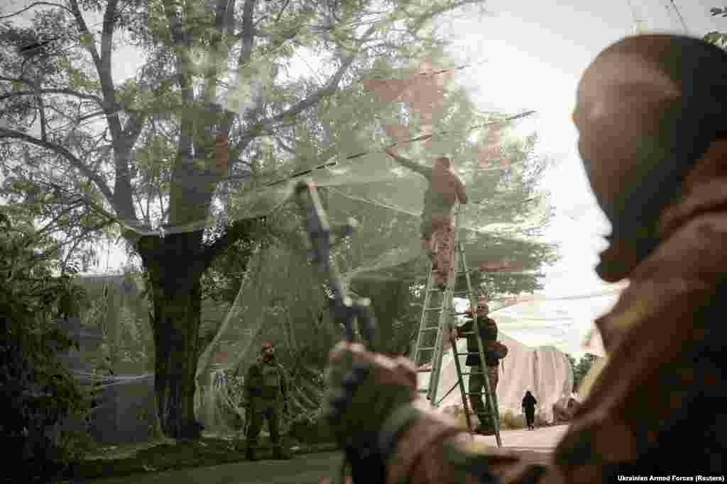 Ushtarët ukrainas duke e instaluar një rrjetë antidronë në Kostiantivka, në Donjeck më 19 shtator 2025.