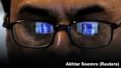 FILE: Facebook logo is reflected in the glasses of a Pakistani user.