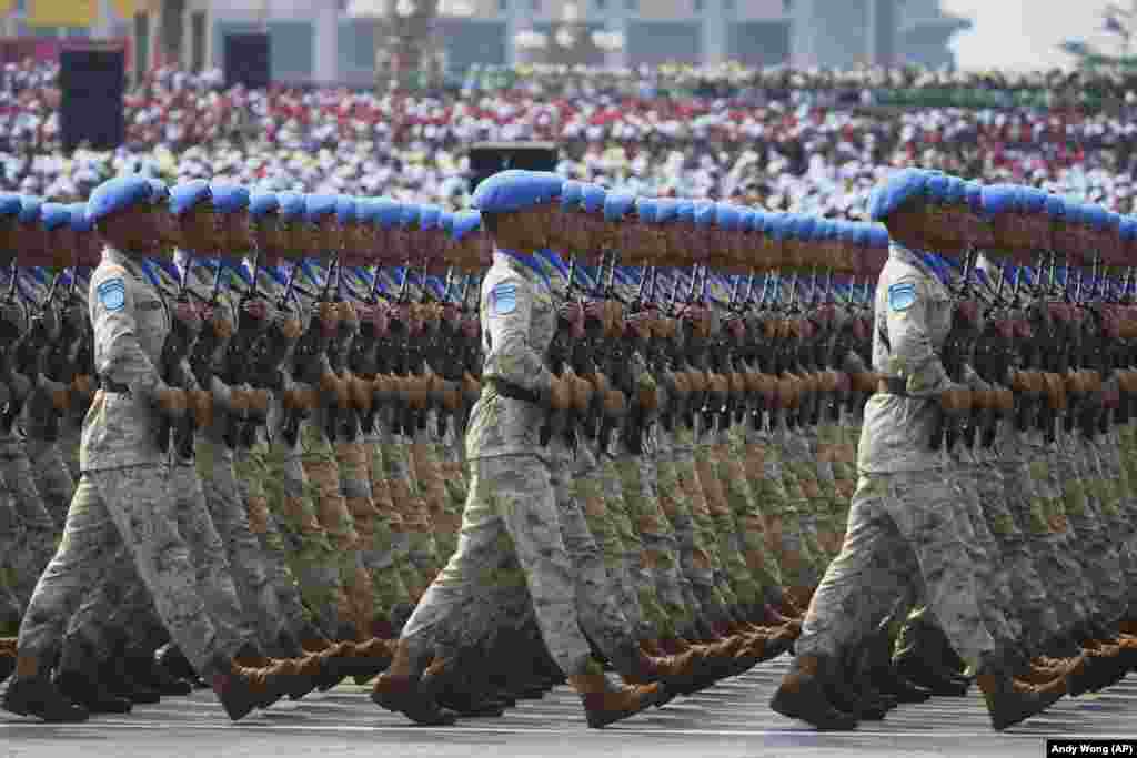 Ushtarë kinezë me kapela të kaltra duke parakaluar.