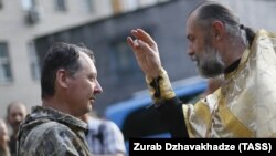 An Orthodox priest blesses pro-Russian separatist commander Igor Strelkov (left) during a religious service in the eastern city of Donetsk on July 10.