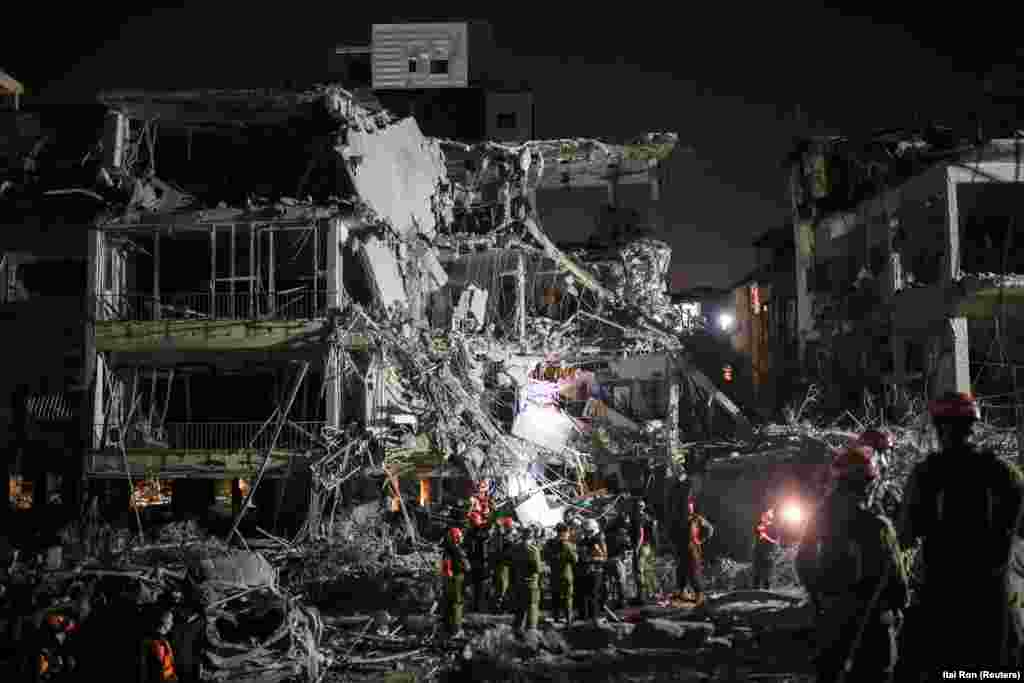 Spasioci i zaštitari rade na lokaciji pogođenoj iranskim napadom u Ramat Ganu, 13. juna.