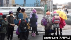 Ученики школы-лицея № 46 города Шымкента в ожидании автобуса, который доставит их в другую школу, поскольку в их учебном заведении не завершен ремонт. 24 ноября 2014 года.