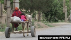 Lebap welaýatynyň etraplarynyň birinde eşekli arabada barýan ene we agtyk.