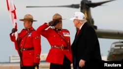 Un ofițer al Poliției Regale Călare a Canadei salutând, în momentul în care președintele american, Donald Trump, coboară din avion la sosirea sa în Canada, pe 15 iunie, înainte de întâlnirea liderilor G7 la Kananaskis