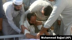 په صوابۍ کې د يوه وژل شوي ځوان د جنازې کټ ته د هغه خپلوان او ملګري غونډ شوي - عکس له ارشېفه 