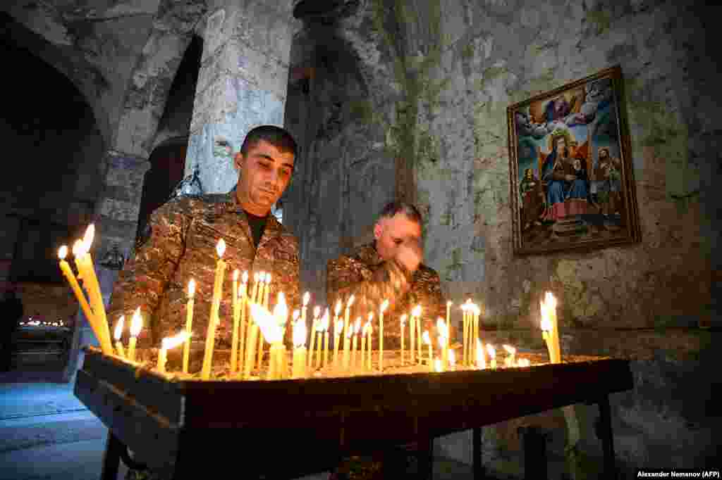 Armenian soldiers light candles as they pay tribute to the dead inside the monastery.